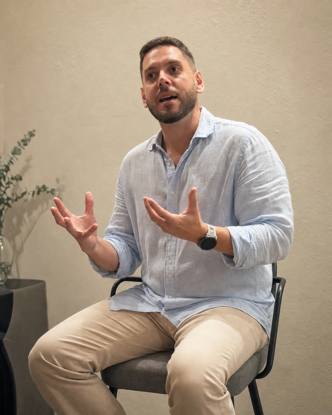 Gustavo Faria falando e gesticulando em uma sala.